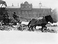 Snöplog på Gustav Adolfs Torg efter snöstormen i april 1912. I bakgrunden Arvfurstens palats.