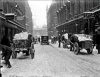 Snöskottning på Drottninggatan. I bakgrunden syns Riksdagshusets portal.