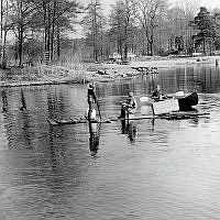 Barn seglar på hemmagjord flotte.