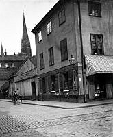 Kammakargatan österut från Stora Bastugatan (nu Sveavägen) med Johannes kyrka i fonden. T.h. Kammakargatan 11, kv. Moraset. En pojke cyklar.