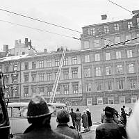 Människor som betraktar släckningsarbete på taket till Arvid Nordquist HAB, Biblioteksgatan 27.