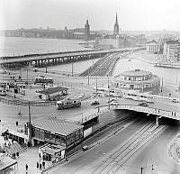 Utsikt över Slussen mot Riddarholmen och Stadshuset. T.h. i bakgrunden Mälartorget. Trådbussar och spårvagnstrafik.