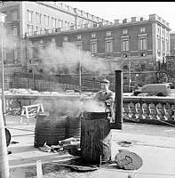 Asfaltkokare på Södra Helgeandstrappan. I bakgrunden Lejonbacken och Stockholms slott.