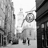 Hörnet Skomakargatan - Stortorget mot Trångsund och Storkyrkan. I förgrunden skylt för Fratis källare. Till vänster en parkerad bryggeribil med reklam för Carnegie porter.