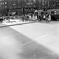 Sveavägen vid korsningen med Kungsgatan. I bakgrunden kv. Hästhuvudet. Fotgängare passerar på övergångsstället.