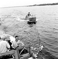 Två motorbåtar med passagerare. I Stockholms norra skärgård.