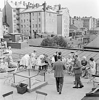 Sommarklädda människor samlade på takterrass på Bonnierhuset, Sveavägen 56.