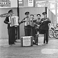 En grupp från Frälsningsarmén sjunger samt spelar dragspel och mandolin på gatan.