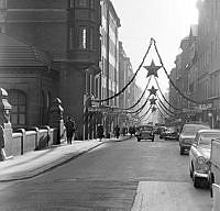 Regeringsgatan med juldekorationer söderut från bron över Kungsgatan. T.v. kv. Bocken, t.h. kv. Stuten.