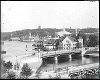 1897 års Allmänna konst- och industriutställning sedd från Strandvägen.
Närmast provisorisk bro till området och i bakgrunden Djurgårdsbron