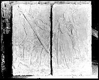 Relief med knäböjande riddare med svärd och bedjande jungfru/prinsessa.