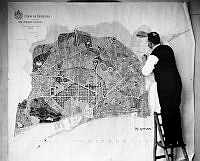 Arkitekt P. Hallman i arbete med karta över Barcelona, 