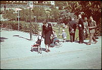 Björns trädgård sedd från korsningen Götgatan - Tjärhovsgatan. Kvinna med småbarn och till höger en grupp män på trottoaren.