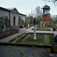 Prins Eugens Waldemarsudde; planteringar och skulpturer i trädgården. Vy åt öster mot oljekvarnen.