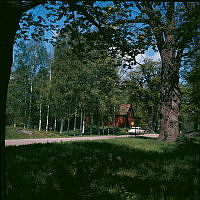 Gamla Djurgårdsekar och röd lada vid hörnet av Prinsessan Ingeborgs Väg och Prinsessan Märtas Väg.