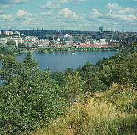 Vy från Nybohovsberget över sjön Trekanten mot industriområde i Liljeholmen. I fonden Högalid.