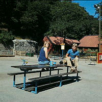 Två ungdomar sitter på ett bord vid parkleken i Observatorielunden.