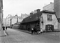 Luntmakargatan norrut från Rehnsgatan 20 t.h. Längs gatan finns bageri, glasmästare och förgyllare, cigarraffär samt vedhandel.