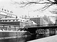 Kv. Atomena och kv. Milon. Vy från Hessensteinska palatset. Den gamla Riddarholmsbron revs 1952 i samband med att tunnelbanan och Centralbron anlades.