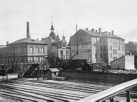 Utsikt från bron över Östra Järnvägsgatan mot Gamla Kungsholmsbrogatan i sydväst. Husen revs 1904. Dåv. kv. Karpen och Braxen, senare Centralbangården och nuv. kv. Blekholmen.
