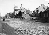 Tulegatan t.v. och Pärlstickaregränden t.h. Fotografiet är taget från Rådmansgatan. Husen revs och gatan försvann 1904.