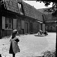 Några barn leker på gårdssidan av Fjällgatan 6. Nuv. Mäster Mikaels Gata 6.