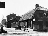 Åsögatan västerut från Södermannagatan. Ett hästfordon står vid Åsögatan 43. Huset revs 1903. Nuv. Åsögatan 139.