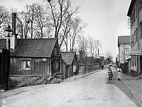 Två flickor passerar Åsögatan 141 österut från Skeppargränd. Nuv. Åsögatan 195. T.h. kv. Oljan.