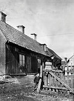 Två pojkar leker på staket vid en träkåk. Huset ligger norr om Vita Berget i kv. Hatten mellan Skånegatan och Bondegatan, senare kv. Kopparn.
