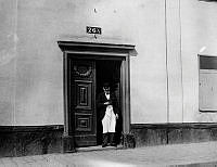 En man står i porten till Götgatan 76 A. Nuvarande Götgatan 138. I kvarteret ligger nu Åhléns varuhus på Södermalm.