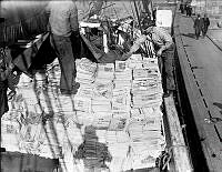 En båt lastas med tidningar som ska till pappersbruk.