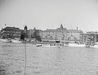 Grand Hotell från Skeppsbron. Båten på Strömmen mitt i bilden är kungaslupen 
