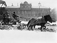 Snöplog på Gustav Adolfs Torg efter snöstormen i april 1912. I bakgrunden Arvfurstens palats.