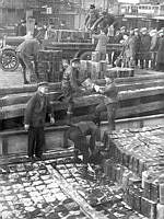 Smuggelsprit lossas i Stadsgårdshamnen efter det stora spritbeslaget vid Sundskär, natten till den 10 mars 1930. Tull och polis beslagtog mer än 20000 liter sprit.