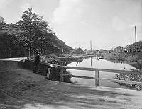 Hammarby sjö med Danviksklippan till vänster och Liljeholmens stearinfabrik till höger. I förgrunden vägen mot Sickla.