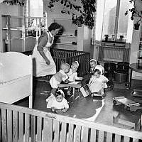 Barnsköterskan Signe Lindberg tillsammans med med fem små barn på Maria barnkrubba.
