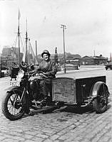 Kvinna på motorcykel med vagn vid Klara Strand.