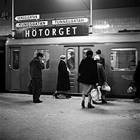 Perrong på T-banestationen Hötorget. Resenärer och inkommande tåg.