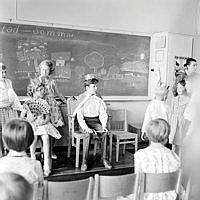 Elever i lågstadiet uppträder i klassrummet vid skolavslutningen. Enskedefältets skola.