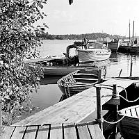 Fiskeläge i Rävsnäs med brygga och förtöjda båtar.