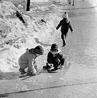 Barn leker i snösmältningen.
