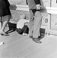 Litet barn kikar på schaktningsarbete i city genom ett ståltrådsstaket.
