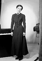 Porträtt av skådespelerskan Signe Hasso stående vid ett piano.