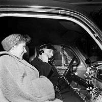 Taxichaufför Einar Söderberg demonstrerar en taxiradioanläggning hos Huddingetaxi för passageraren fröken Henriksson.