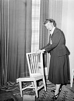 Fru Edna Martin visar en stol från föreningen Svensk hemsöjds slöjdskola i Siljansnäs under hemslöjdsjubileum. Stolen är från omkring 1905.