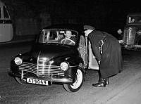 Polisen gör bilrazzia. En polis lutar sig in i en Renault, där en man sitter vid ratten.
