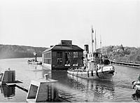 Liljeholmsbadet bogseras till Hammarbyvarvets torrdocka för översyn och reparation, av bogserbåten 