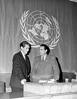 Sveavägen 65, Handelshögskolans Aula. FN-dagen firas. Två män framför FN-flaggan.