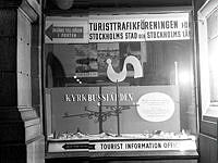Gustav Adolfs Torg 18, Turisttrafikföreningen för Stockholms stad och Stockholms läns upplysningsbyrå. Skyltfönster med reklam för kyrkbussarna.