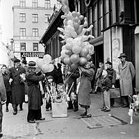 Hötorget, Hötorget 12, hörnet av Oxtorgsgatan och Sergelgatan. En ballongförsäljare utanför gamla Hötorgshallen.